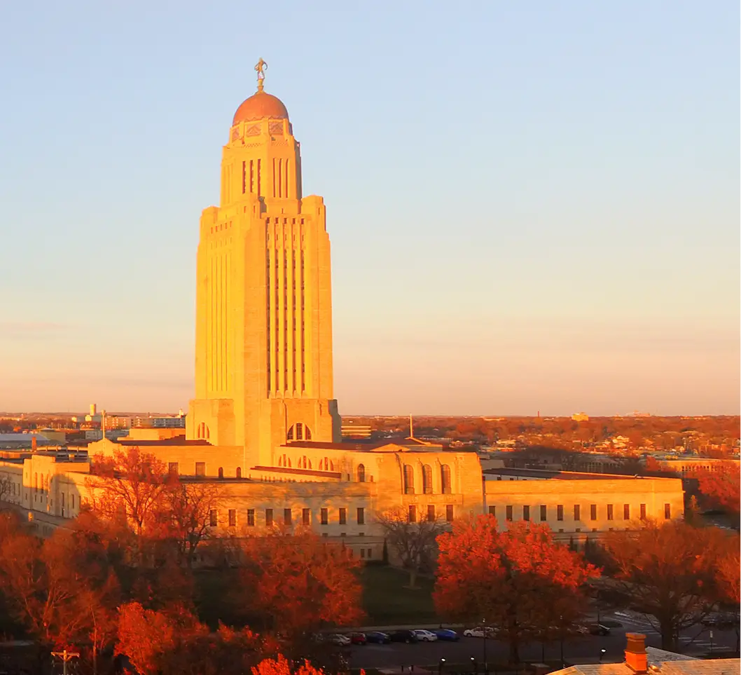 Nebraska State Capitol building at sunset, autumn foliage