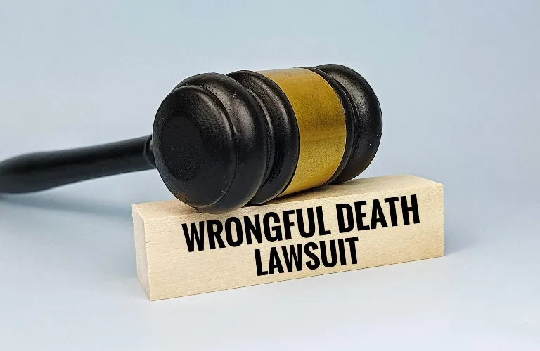 Wooden judge's gavel resting on a block labeled "Wrongful Death Lawsuit" against a light background.
